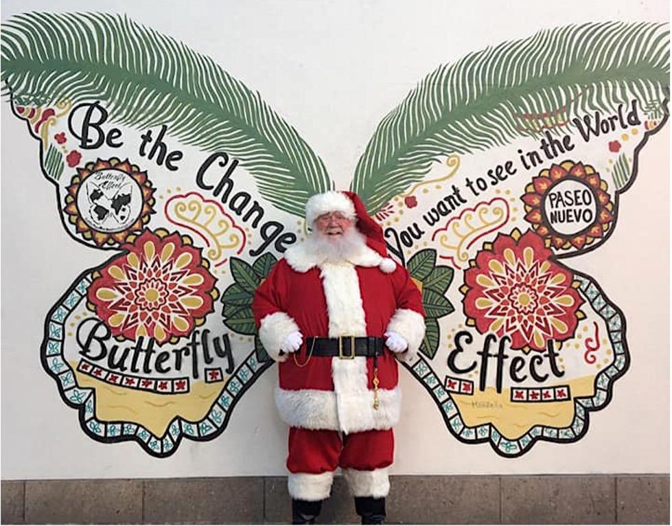 Santa Robert poses in front of a wall mural