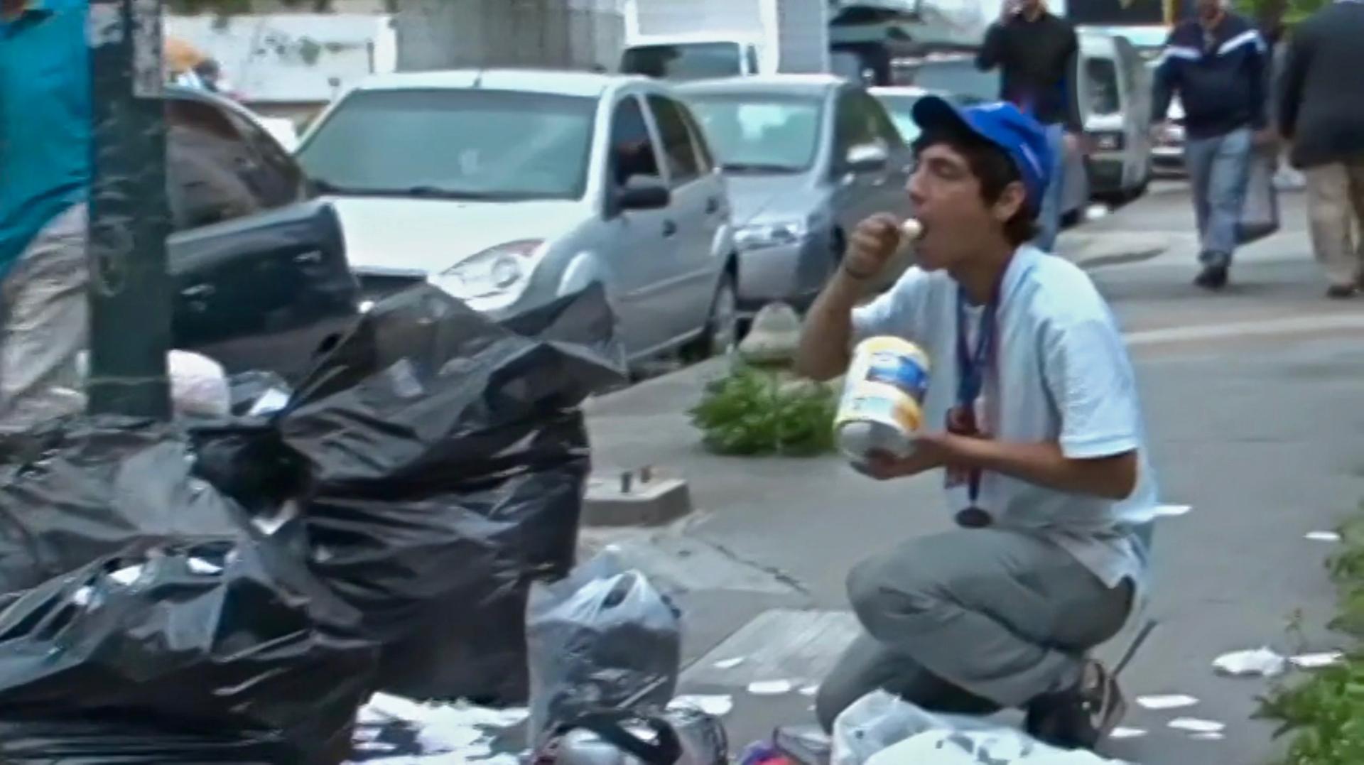 homeless man eats from garbage in Venezuela